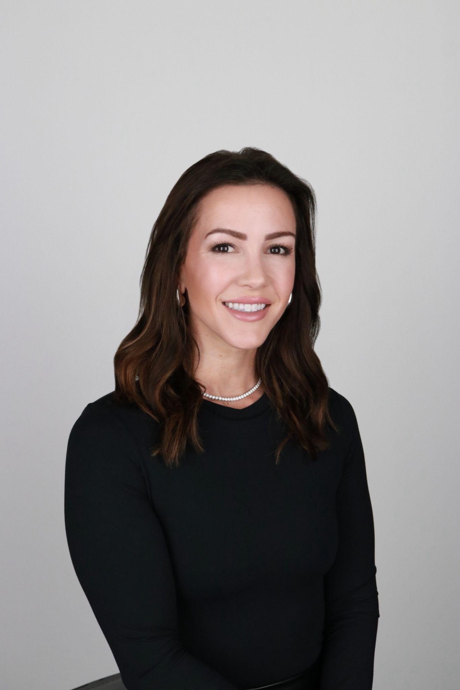 A consistent professional team headshot on a clean gray studio background
