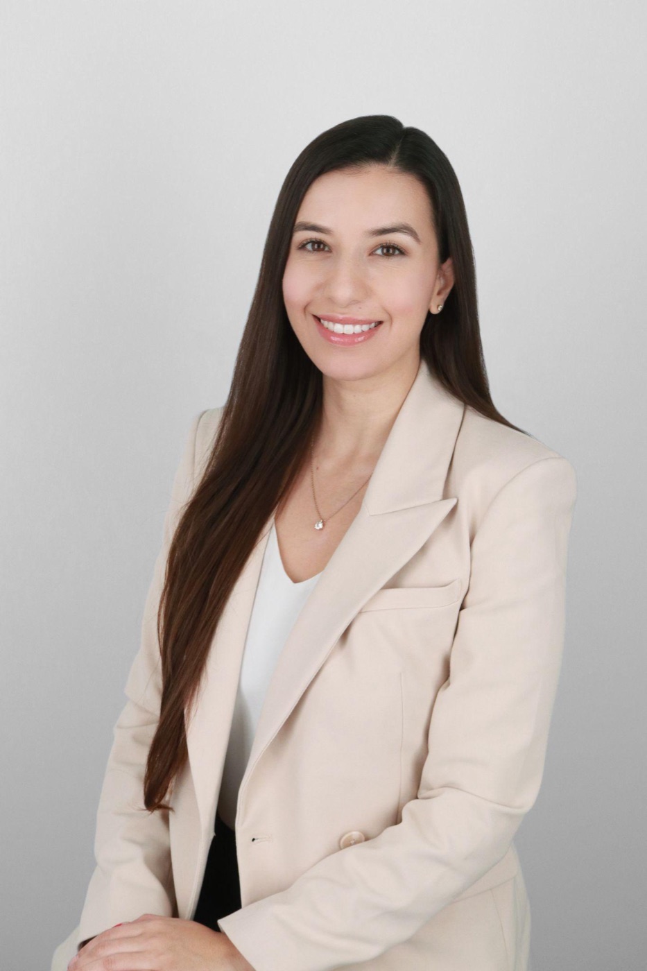 A professional headshot with clean lighting, a simple background, and a confident, natural expression