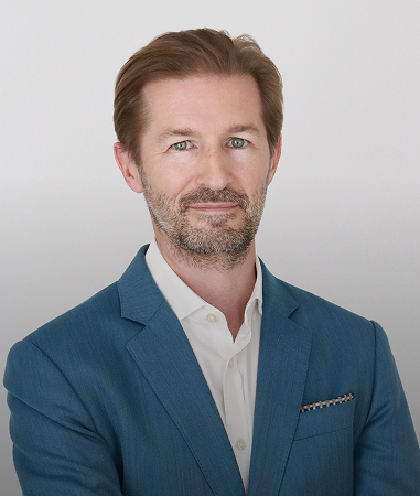Speaker card headshot, executive portrait, clean backdrop.
