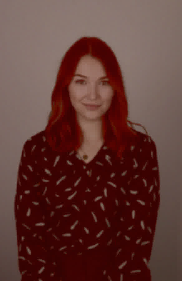 The same person photographed on a phone camera in poor office light.